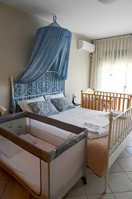 a bedroom with a bed with a blue canopy at Melrose maisonette by the sea in Anavissos