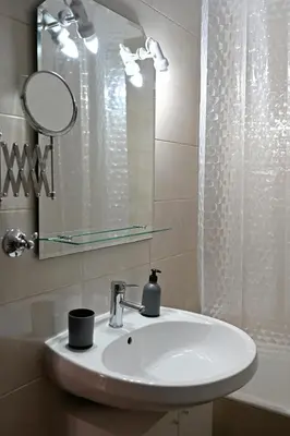 a bathroom sink with a mirror and a shower at Melrose maisonette by the sea in Anavissos