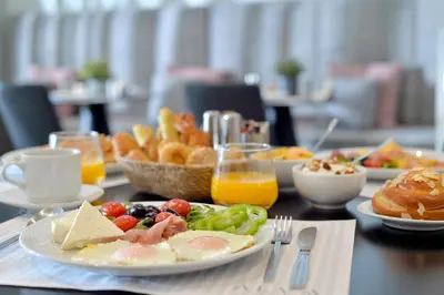 a table topped with plates of food and breakfast foods at Alva Athens Hotel in Athens
