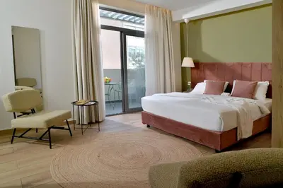 a bedroom with a large bed and a balcony at Alva Athens Hotel in Athens