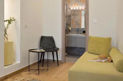 a living room with a couch and a chair at Alva Athens Hotel in Athens