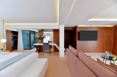 a living room with a couch and a tv at Alva Athens Hotel in Athens
