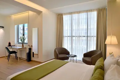 a hotel room with a bed and a desk and chairs at Alva Athens Hotel in Athens