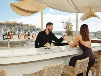 a man and a woman sitting at a bar at The Lekka Hotel & Spa in Athens