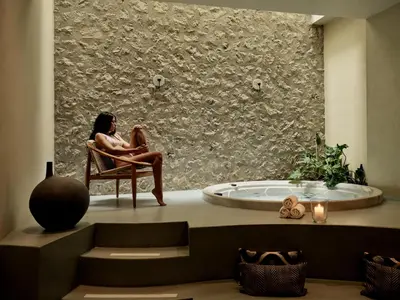 a woman sitting in a chair in a room with a tub at The Lekka Hotel & Spa in Athens