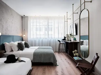 a bedroom with two beds and a desk and a mirror at The Lekka Hotel & Spa in Athens