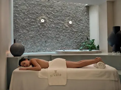 a woman laying on a bed in a room at The Lekka Hotel & Spa in Athens