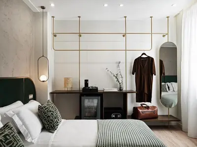 a bedroom with a bed and a dresser and a mirror at The Lekka Hotel & Spa in Athens