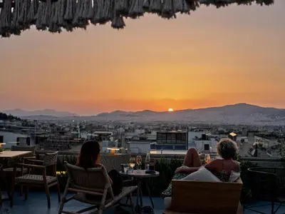 a group of people sitting in chairs watching the sunset at The Lekka Hotel & Spa in Athens