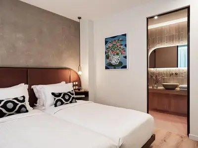 a bedroom with two beds and a bathroom at The Lekka Hotel & Spa in Athens