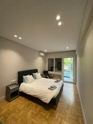 a bedroom with a large bed and a large window at Optimal Point - Spacious Koukaki Apt in Athens