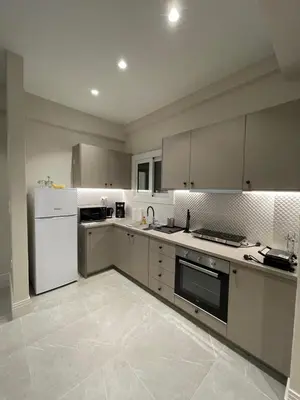 a kitchen with white appliances and white cabinets at Optimal Point - Spacious Koukaki Apt in Athens