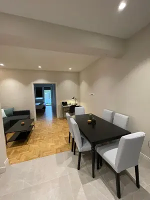 a dining room with a black table and white chairs at Optimal Point - Spacious Koukaki Apt in Athens