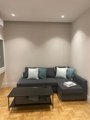 a living room with a couch and a coffee table at Optimal Point - Spacious Koukaki Apt in Athens
