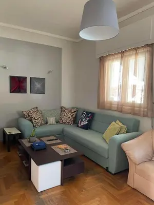 a living room with a blue couch and a table at Home Sweet Home - 2 bedroom apartment in Athens