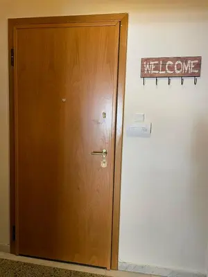 a wooden door in a room with a sign on the wall at Home Sweet Home - 2 bedroom apartment in Athens