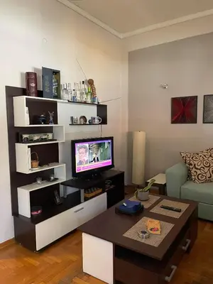 a living room with a tv and a couch and a table at Home Sweet Home - 2 bedroom apartment in Athens
