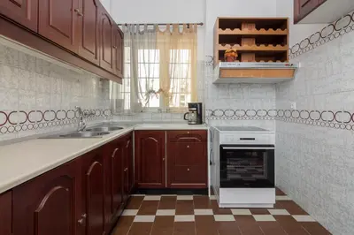 a kitchen with wooden cabinets and a sink and a stove at Nice 2bedroom apartment in Pagkrati in Athens