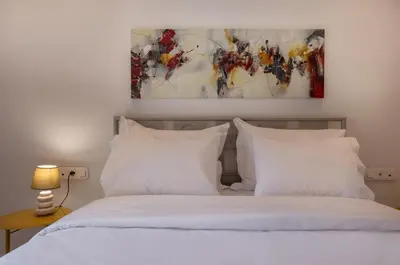a bedroom with a bed with white pillows and a painting at niovi cozy home in Athens