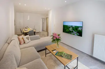 a living room with a couch and a tv on a wall at niovi cozy home in Athens