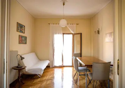 a dining room with a table and chairs and a window at Sunny Apartment (90m2) in Athens center in Athens
