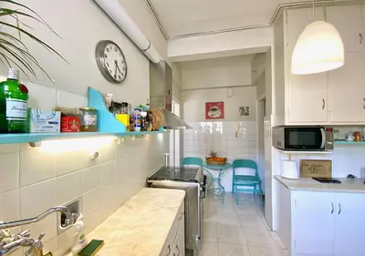 a kitchen with a counter and a clock on the wall at Sunny Apartment (90m2) in Athens center in Athens