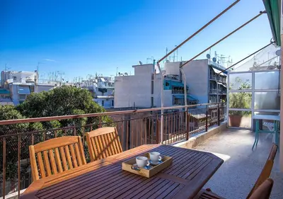 a wooden table and chairs on a balcony at Sunny Apartment (90m2) in Athens center in Athens