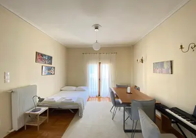 a bedroom with a bed and a table and a desk at Sunny Apartment (90m2) in Athens center in Athens