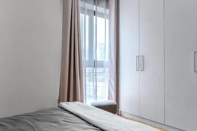 a bedroom with a bed and a large window at Athena Studio in Gazi in Athens