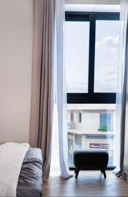 a bedroom with a bed and a large window at Athena Studio in Gazi in Athens