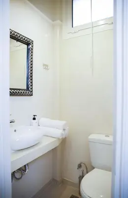 a white bathroom with a sink and a toilet at Praxitelis Luxury Apartments in Athens
