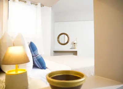 a bedroom with a bed and a lamp on a table at Praxitelis Luxury Apartments in Athens