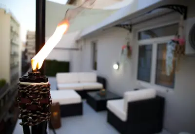 a lit candle on a balcony with a living room at Praxitelis Luxury Apartments in Athens
