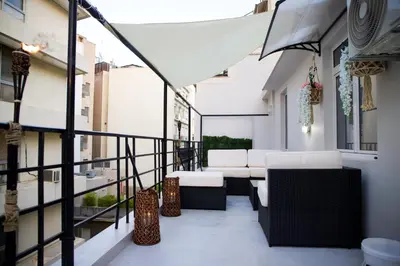 a balcony with chairs and tables on a building at Praxitelis Luxury Apartments in Athens