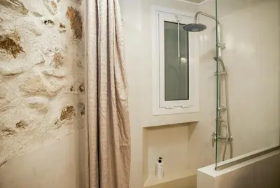 a bathroom with a shower curtain and a mirror at Praxitelis Luxury Apartments in Athens