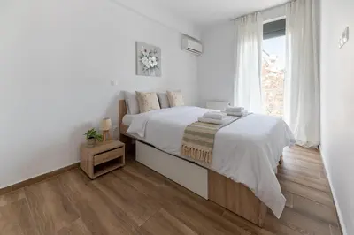 a white bedroom with a large bed and a window at Stylish spacious apartment in Palaio Faliro (C1) in Athens