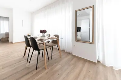 a dining room with a table and chairs and a mirror at Stylish spacious apartment in Palaio Faliro (C1) in Athens