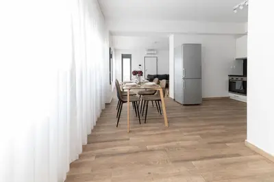 a dining room and kitchen with white walls and a table and chairs at Stylish spacious apartment in Palaio Faliro (C1) in Athens