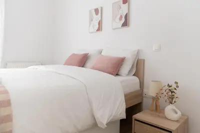 a bedroom with a white bed with pink pillows at Stylish spacious apartment in Palaio Faliro (C1) in Athens