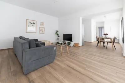 a living room with a gray couch and a table at Stylish spacious apartment in Palaio Faliro (C1) in Athens