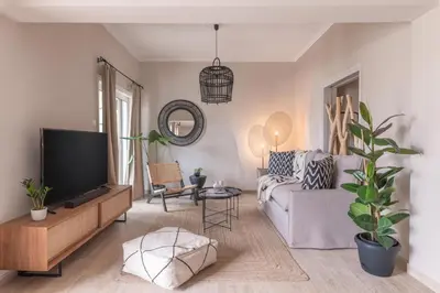 a living room with a couch and a tv at Minimal Retreat w/ Watercoloured Sunset View in Piraeus