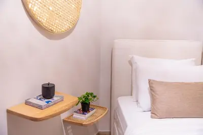 a bedroom with a bed and a side table with a plant at Minimal Retreat w/ Watercoloured Sunset View in Piraeus