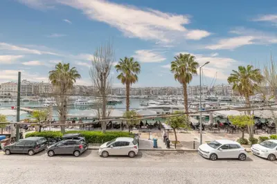 a group of cars parked in a parking lot with palm trees at Minimal Retreat w/ Watercoloured Sunset View in Piraeus