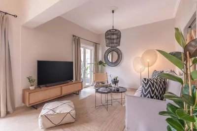 a living room with a television and a couch at Minimal Retreat w/ Watercoloured Sunset View in Piraeus