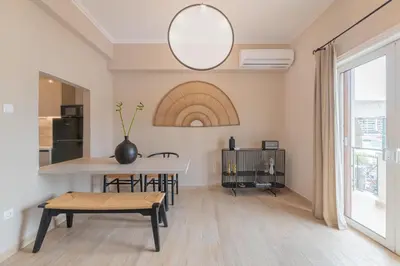 a living room with a table and a kitchen at Minimal Retreat w/ Watercoloured Sunset View in Piraeus