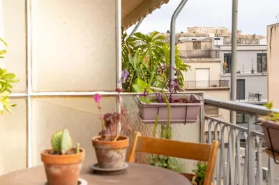 a balcony with a table and potted plants on it at Mosaics central studio apartm with Acropolis view in Athens