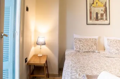 a bedroom with a bed and a table with a lamp at Mosaics central studio apartm with Acropolis view in Athens