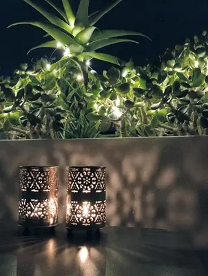 two candles sitting on a table with a plant at Susanna Apartments - Your Oasis in Athens Ano Petralona in Athens