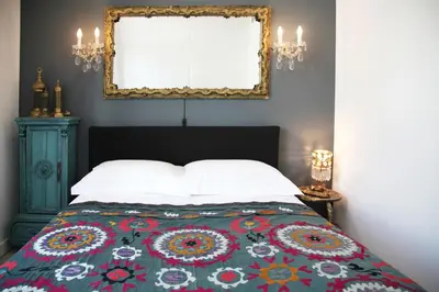 a bedroom with a bed with a flowered blanket and a window at Susanna Apartments - Your Oasis in Athens Ano Petralona in Athens