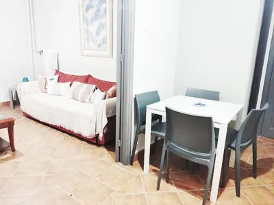 a living room with a table and chairs and a bed at Under the Rock of Acropolis by YHA in Athens
